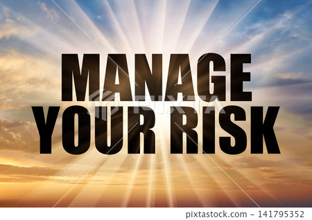 Manage your risk black text against a soft golden evening sky with bright sun rays Manage your risk black text against a soft golden evening sky with bright sun rays 141795352