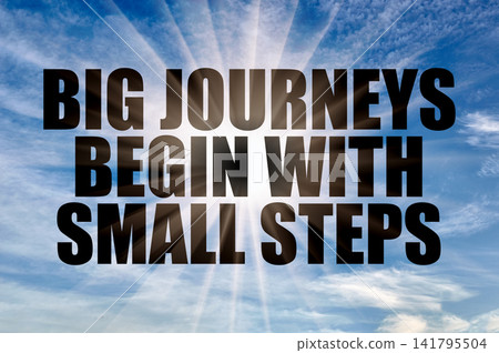 Big journeys begin with small steps phrase on a daytime blue sky 141795504
