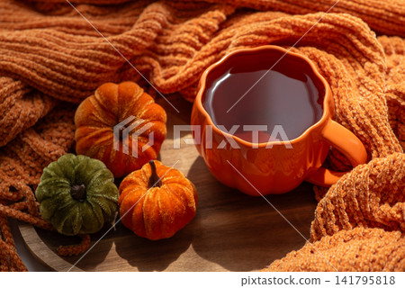 Cozy Autumn Still Life With Pumpkins And Warm Drink Arranged With Textured Fabric For Fall Season Concepts Cozy Autumn Still Life With Pumpkins And Warm Drink Arranged With Textured Fabric For Fall Season Concepts 141795818