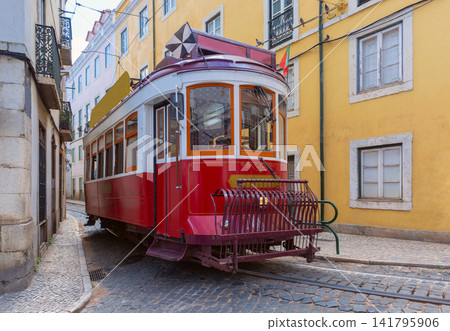 Historic red Lisbon tram on narrow cobblestone street in Alfama Portugal Historic red Lisbon tram on narrow cobblestone street in Alfama Portugal 141795906