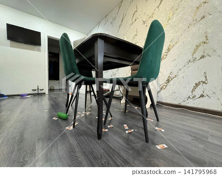 In the kitchen, there is a table with green chairs. Side view, from below. In the kitchen, there is a table with green chairs. Side view, from below. 141795968