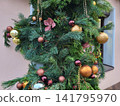 Spruce branches on the facade of the house, decorated with Christmas ornaments. The concept of Christmas and the New Year. 141795970