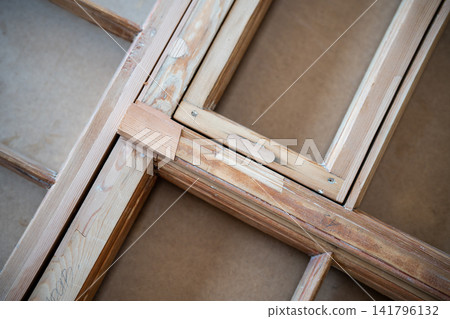 Antique window frame at worktable in restoration workshop undergoing renovation and reconstruction. Antique window frame at worktable in restoration workshop undergoing renovation and reconstruction. 141796132
