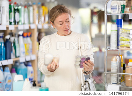 Female shopper chooses scented candles in supermarket for romantic evening Female shopper chooses scented candles in supermarket for romantic evening 141796374