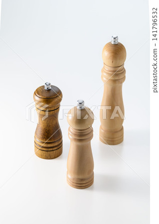 Set of 3 wooden pepper mills, kitchen utensil styling on a white background. Set of 3 wooden pepper mills, kitchen utensil styling on a white background. 141796532