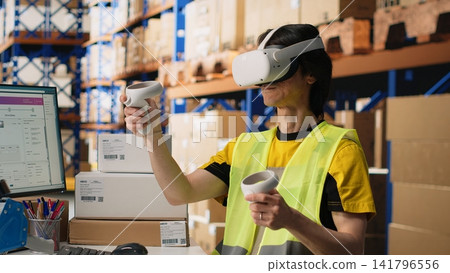 Worker in hi vis vest uses a VR headset connected to AI for hands free inventory control, parcel shipment tracking and order fulfillment. Virtual reality improves fast delivery. Camera B. Worker in hi vis vest uses a VR headset connected to AI for hands free inventory control, parcel shipment tracking and order fulfillment. Virtual reality improves fast delivery. Camera B. 141796556