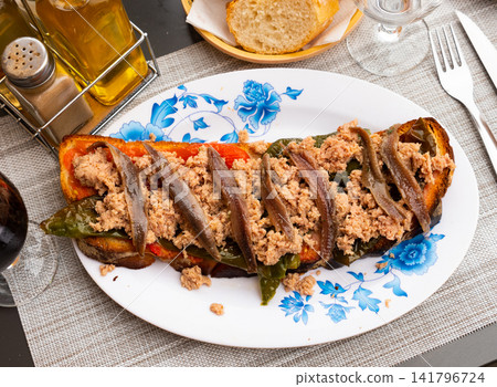 Toast with canned tuna, anchovies and roasted bell pepper 141796724