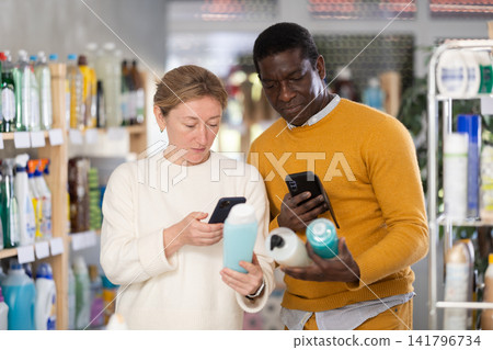 Couple man and woman scanning qr code for shampoo or shower gel Couple man and woman scanning qr code for shampoo or shower gel 141796734