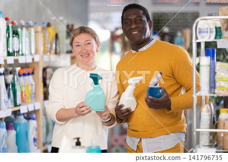 Couple man and woman choosing cleaning spray in store Couple man and woman choosing cleaning spray in store 141796735