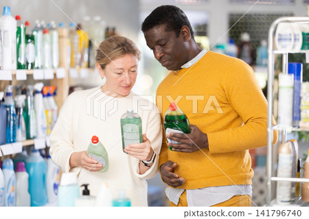 Couple man and woman choosing dishwashing detergent in store Couple man and woman choosing dishwashing detergent in store 141796740
