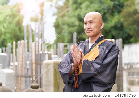 佛教僧侶在墓園靜靜祈禱的肖像。 佛教僧侶在墓園靜靜祈禱的肖像。 141797780