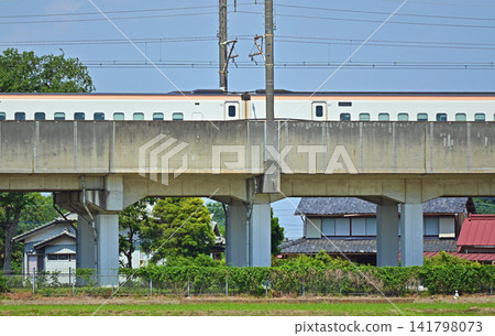 A Shinkansen train running on an elevated bridge. A Shinkansen train running on an elevated bridge. 141798073