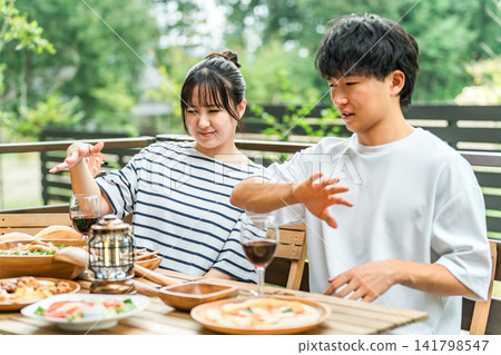 A couple is having trouble with insect bites while eating outdoors. A couple is having trouble with insect bites while eating outdoors. 141798547
