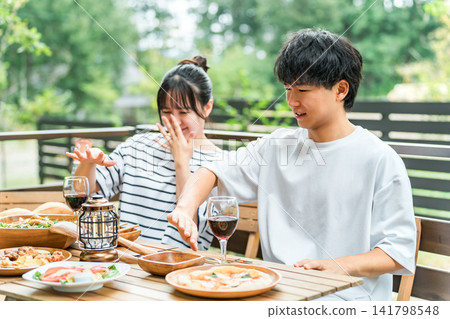 一對夫婦在戶外用餐時飽受昆蟲叮咬之苦。 一對夫婦在戶外用餐時飽受昆蟲叮咬之苦。 141798548