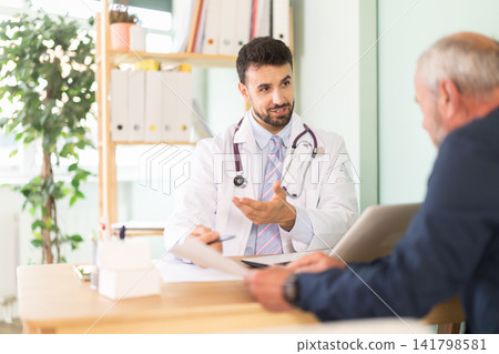 Senior man client of medical clinic sits opposite male doctor and communicates with specialist Senior man client of medical clinic sits opposite male doctor and communicates with specialist 141798581