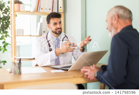 Senior man client of medical clinic sits opposite male doctor and communicates with specialist Senior man client of medical clinic sits opposite male doctor and communicates with specialist 141798596
