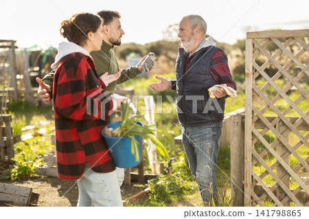 Young couple quarrel with eldery man while gardening Young couple quarrel with eldery man while gardening 141798865