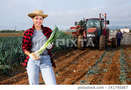 Woman posing with leek crop on field Woman posing with leek crop on field 141798867