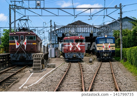老式機車整齊地排列在鐵路車庫。 老式機車整齊地排列在鐵路車庫。 141799735