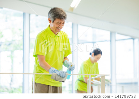 Senior male and female staff cleaning the office Senior male and female staff cleaning the office 141799758