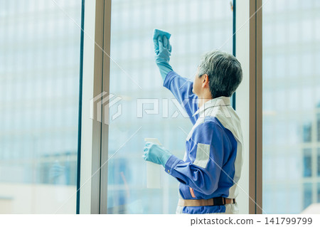 A man in work clothes standing by the window A man in work clothes standing by the window 141799799