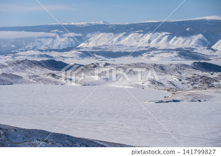 Scenery view of frozen lake Baikal in winter season, the surface of lake covered by snow. Lake Baikal is the world's deepest lake located in southern Siberia, Russia. Scenery view of frozen lake Baikal in winter season, the surface of lake covered by snow. Lake Baikal is the world's deepest lake located in southern Siberia, Russia. 141799827