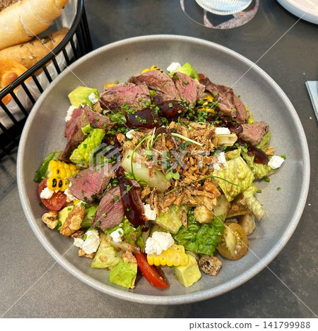 Fresh salad with a mix of crisp leafy greens, sliced vegetables, and colorful ingredients, tossed together to create a healthy, vibrant, and refreshing dish full of natural flavors Fresh salad with a mix of crisp leafy greens, sliced vegetables, and colorful ingredients, tossed together to create a healthy, vibrant, and refreshing dish full of natural flavors 141799988