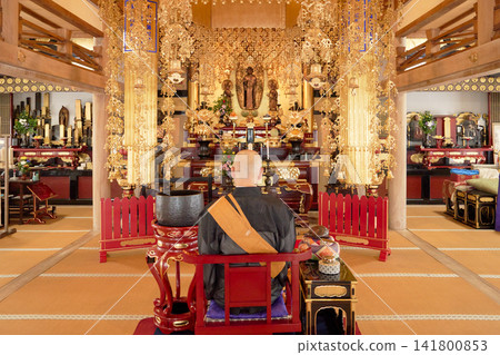 A monk performing a memorial service and the interior of the main hall. A monk performing a memorial service and the interior of the main hall. 141800853