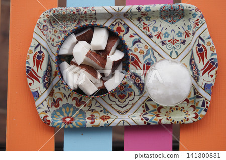 Coconut pieces on a colorful tray with salt Coconut pieces on a colorful tray with salt 141800881
