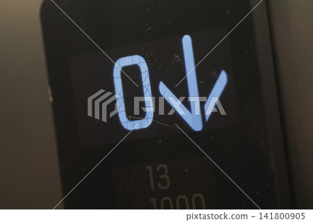 Elevator display shows zero and down arrow in a building 141800905