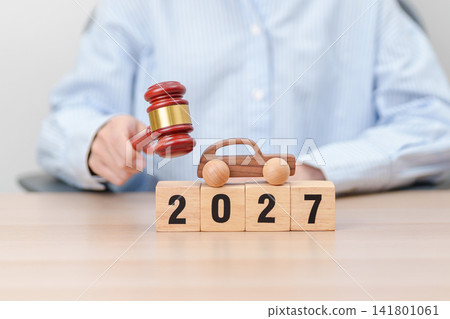 Happy New Year 2027 with small toy car models and Judges gavel on desk in courthouse. Car Law, Insurance, auto Tax, Auction and Bidding concepts 141801061