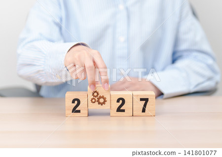2026 year change to 2027 year block with gear icon. Business Process, Team, teamwork, Goal, Target, Resolution, strategy, plan, Action, motivation, change, brainstorm and New Year start concepts 141801077