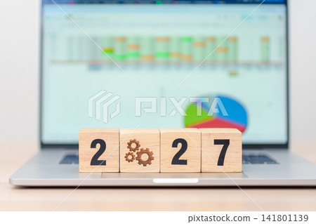 Happy New Year 2027 block with gear icon against laptop computer. Business Process, Team, teamwork, Goal, Target, Resolution, strategy, plan, Action, motivation, change and brainstorm Happy New Year 2027 block with gear icon against laptop computer. Business Process, Team, teamwork, Goal, Target, Resolution, strategy, plan, Action, motivation, change and brainstorm 141801139