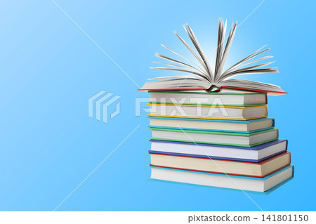 Books are stacked with one open on top against a blue background Books are stacked with one open on top against a blue background 141801150