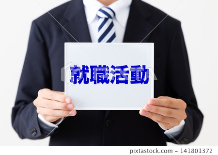 身穿西裝的年輕商人,手持白板尋找工作。 身穿西裝的年輕商人,手持白板尋找工作。 141801372