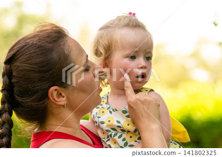 Mother Touching Toddler Daughter Cheek in Park 141802325
