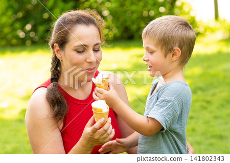 Young Son Offering Ice Cream Cone to Mother Young Son Offering Ice Cream Cone to Mother 141802343