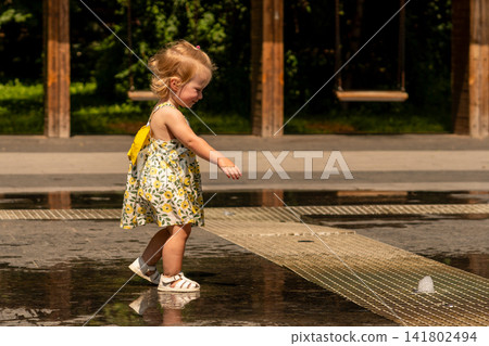 Toddler Girl Walking Through Outdoor Splash Fountain Alone Toddler Girl Walking Through Outdoor Splash Fountain Alone 141802494