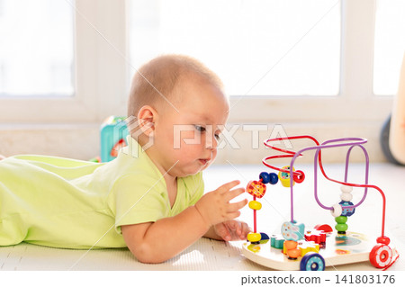 Baby Boy Reaches For Beads On Educational Maze Toy Baby Boy Reaches For Beads On Educational Maze Toy 141803176