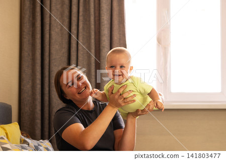 Baby Boy Touches Mother Chin During Playful Window Moment Baby Boy Touches Mother Chin During Playful Window Moment 141803477