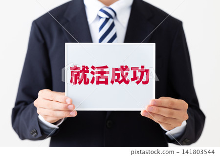 A young businessman in a business suit holding a whiteboard displaying job-hunting success stories. A young businessman in a business suit holding a whiteboard displaying job-hunting success stories. 141803544