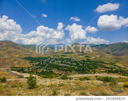 Panoramic view of valley nestled between rolling hills Panoramic view of valley nestled between rolling hills 141803624