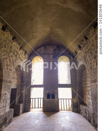 Sunlit ancient chapel interior with stone arches and vaulted ceiling Sunlit ancient chapel interior with stone arches and vaulted ceiling 141803646
