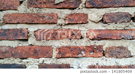 Dark red clay brick wall with a rough mortar texture. Dark red clay brick wall with a rough mortar texture. 141805409
