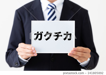 A young businessman in a business suit holding a whiteboard listing his extracurricular activities. A young businessman in a business suit holding a whiteboard listing his extracurricular activities. 141805892