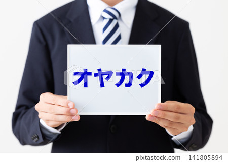 A young businessman in a business suit holding a whiteboard for Oyakaku (a company). A young businessman in a business suit holding a whiteboard for Oyakaku (a company). 141805894