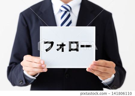 一位身穿西裝的年輕商人手持白板。 一位身穿西裝的年輕商人手持白板。 141806110