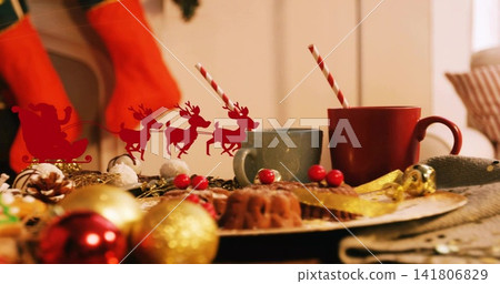Displaying holiday table in living room with plate of bundt cakes, two striped mugs, Santa cutout Displaying holiday table in living room with plate of bundt cakes, two striped mugs, Santa cutout 141806829
