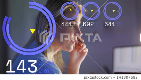 Holding headset, mature woman wearing blue top monitoring HUD rings and readouts on office monitor Holding headset, mature woman wearing blue top monitoring HUD rings and readouts on office monitor 141807682