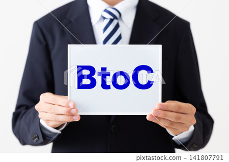 A young businessman in a business suit holding a B2C whiteboard. A young businessman in a business suit holding a B2C whiteboard. 141807791
